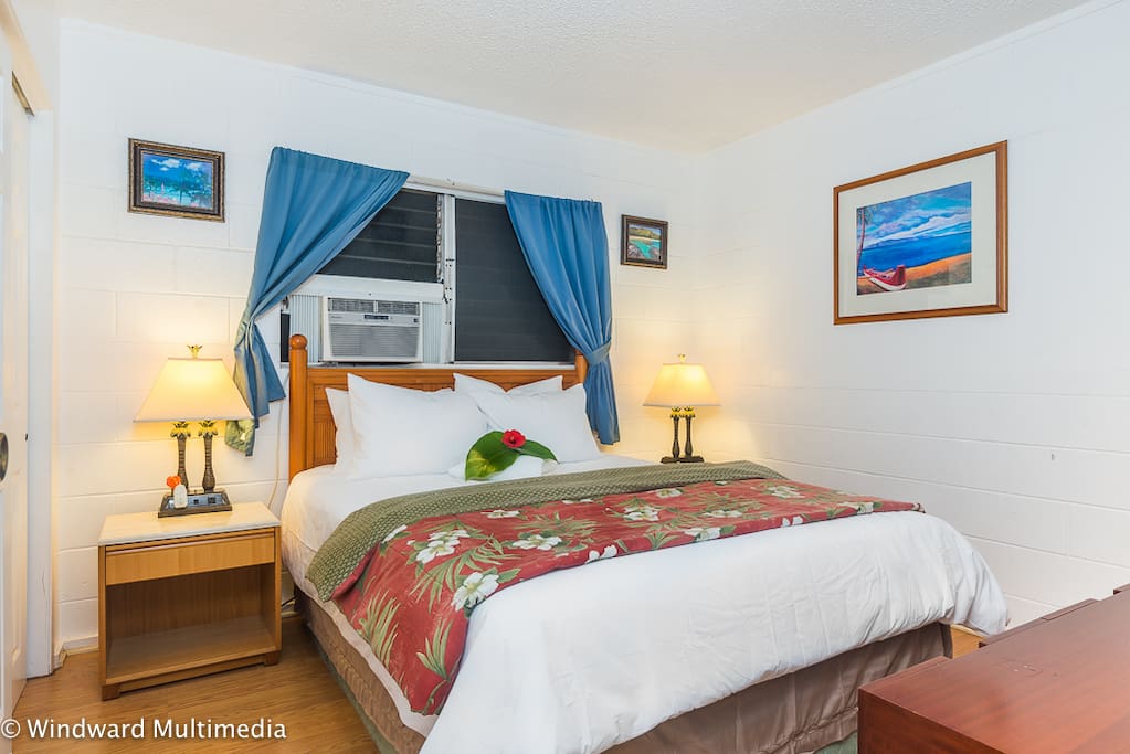 Bedroom with queen bed and window AC unit