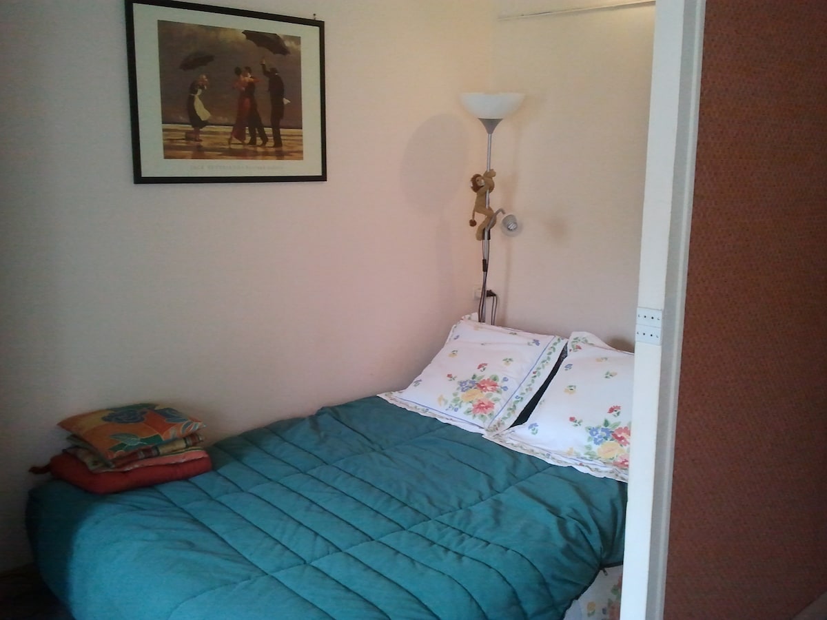 Dormitorio con cama doble contigua a la sala de estar