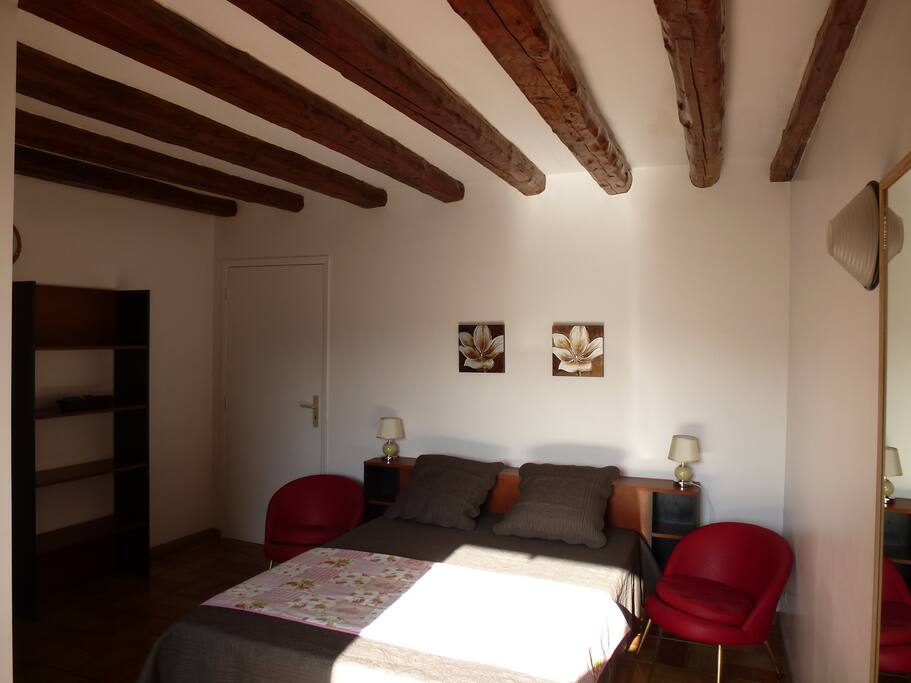 Chambre avec poutres en bois au plafond.