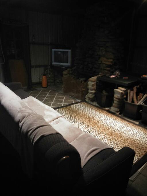 Spacious outdoor undercover area with open wood fire, couch TV, cd/ radio player