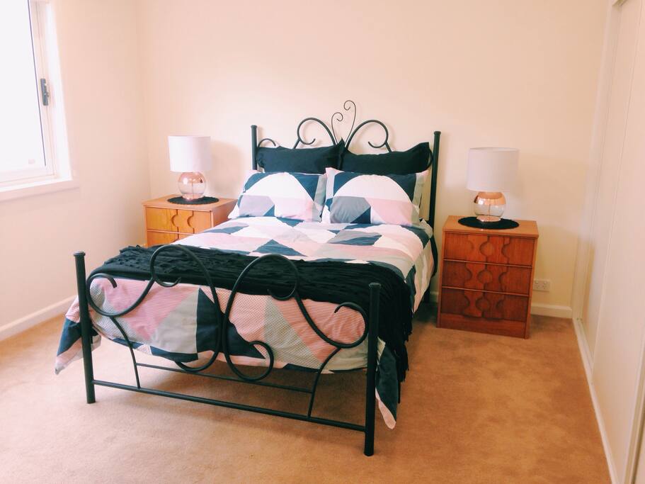 Generous sized separate bedroom includes comfortable double bed and multiple storage spaces.