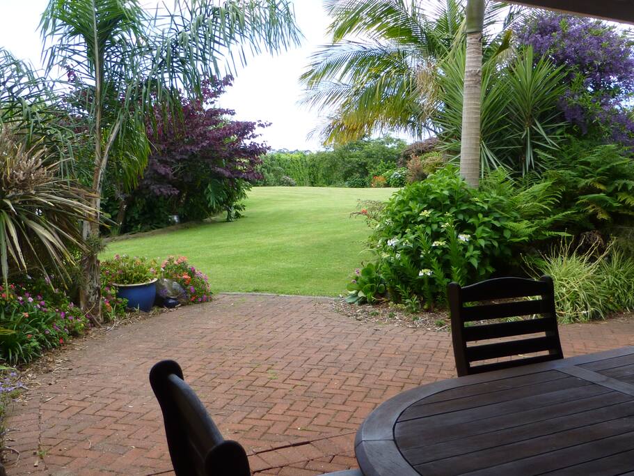 Private BBQ dining area with entrance to parklike gardens