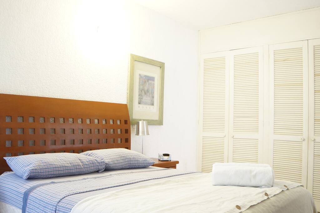 Queen bed with a big closet, air conditioner and fan