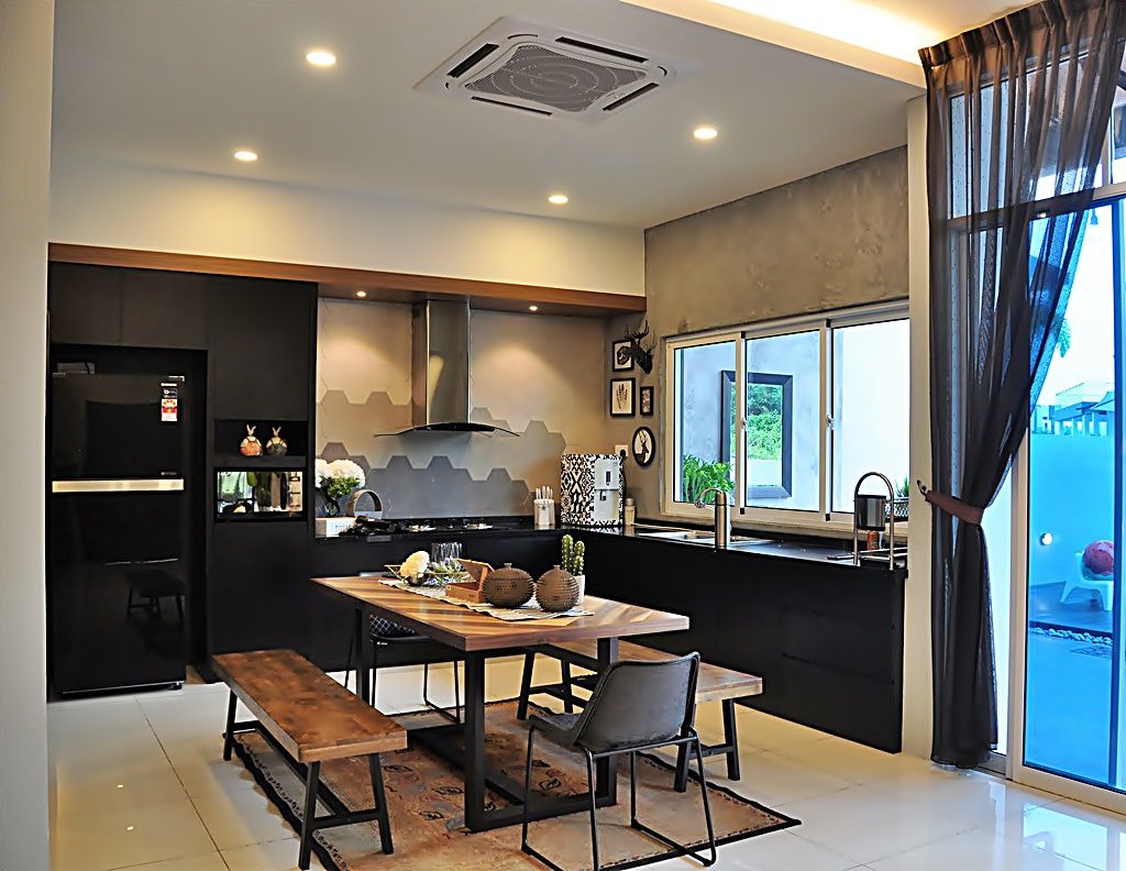 A modern kitchen area is showcased with sleek black cabinetry and a spacious dining table. A large window allows natural light to fill the space, highlighting the tasteful decor. Contemporary appliances are present, along with a cozy seating arrangement made up of benches and a chair.