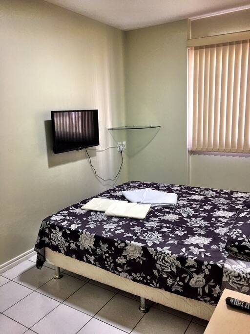Quarto com cama de casal, TV e Arcondicionado.