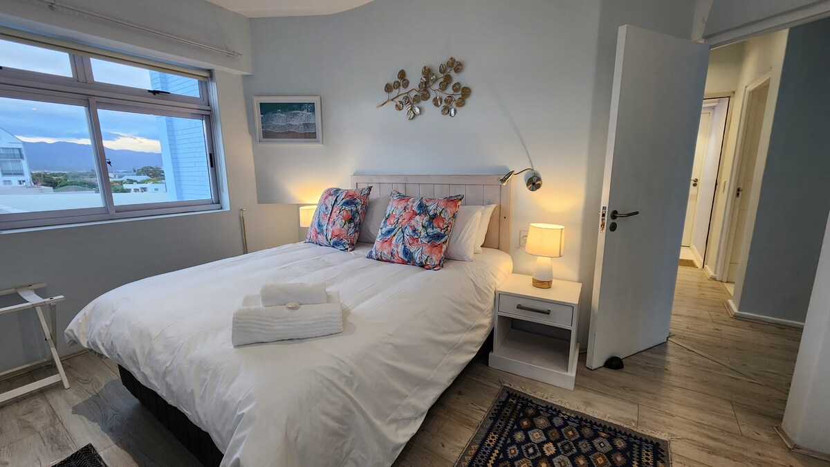 Dhomë gjumi kryesore me pamje nga një dritare dhe pamje nga oqeani nga dritarja (më e vogël).
