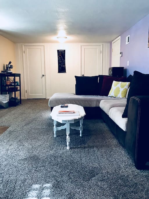 Living area with comfy couch, fridge, microwave, coffee, TV, DVD player and DVDs, Amazon Echo, Chromecast, and plenty of room for air mattress (provided along with extra sheets, pillows, and blankets).