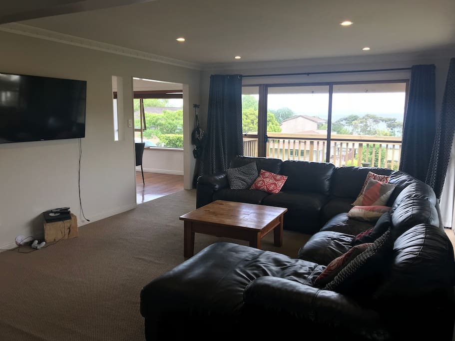Lounge with large comfy couch for the whole family. PlayStation, Netflix and Lightbox. Leads out to deck with view