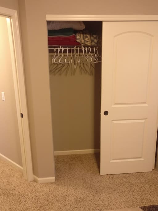 Sliding door closet with extra blankets and pillows and to hang any clothes.