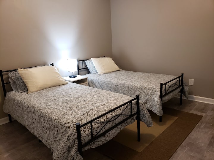 Camera al piano di sotto con letti singoli e smart tv.