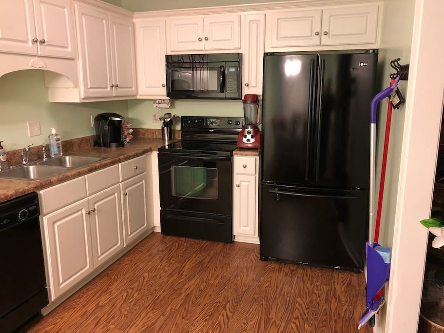 Kitchen with dishwasher, microwave, refrigerator, stove, oven, and all plates, glasses, and cutlery