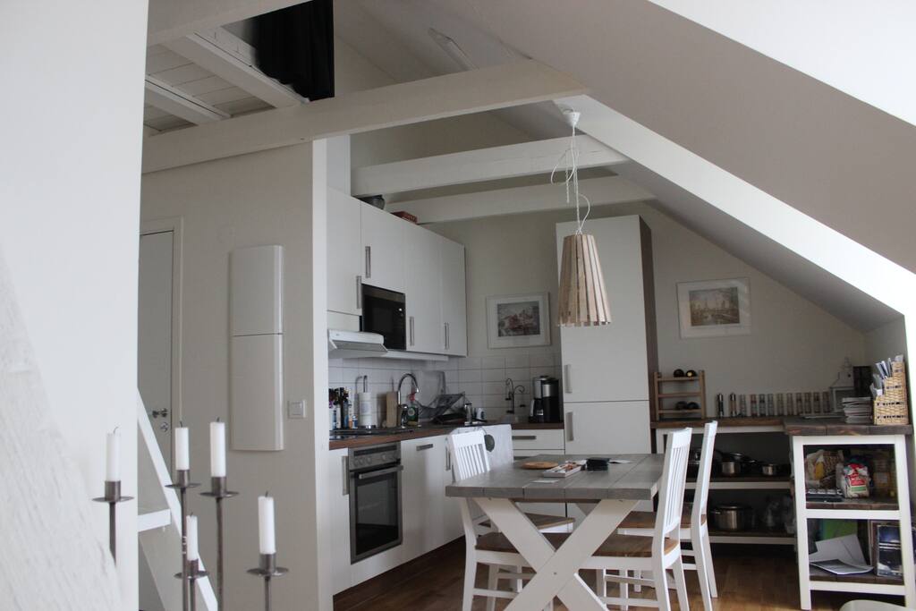 View of kitchen from the sitting room. Plenty of space for dinner and cooking. On the top left corner of the picture you can see the sleeping loft.
