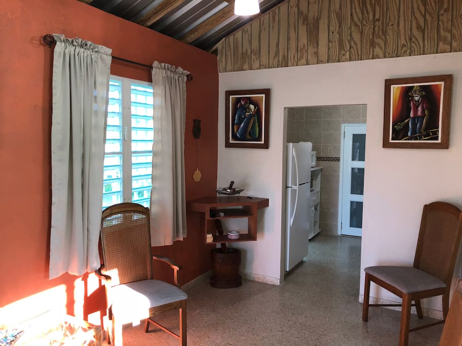 Parte de la sala con vista a la cocina y baño.
