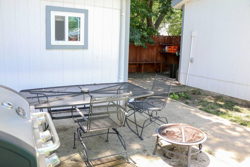Private, fenced backyard with table and chairs along with a gas grill.
