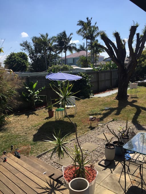 Tidy backyard with paved outdoor space and table for 4. Small electric BBQ in kitchen for use outdoors.