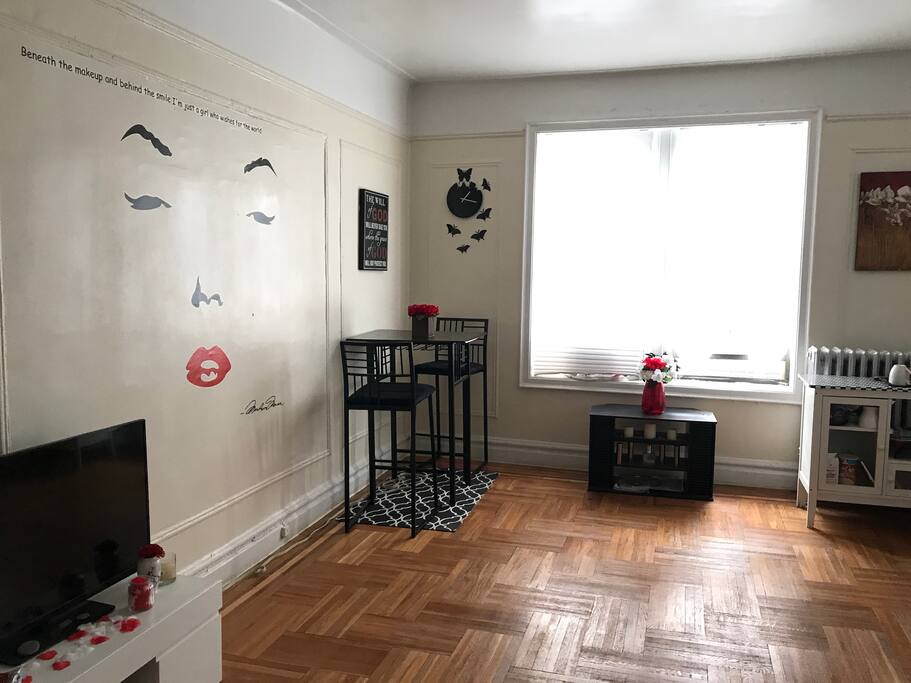 Spacious well lit Living Room with TV (basic channels), Bar dining area, AC unit and tons of natural lighting
