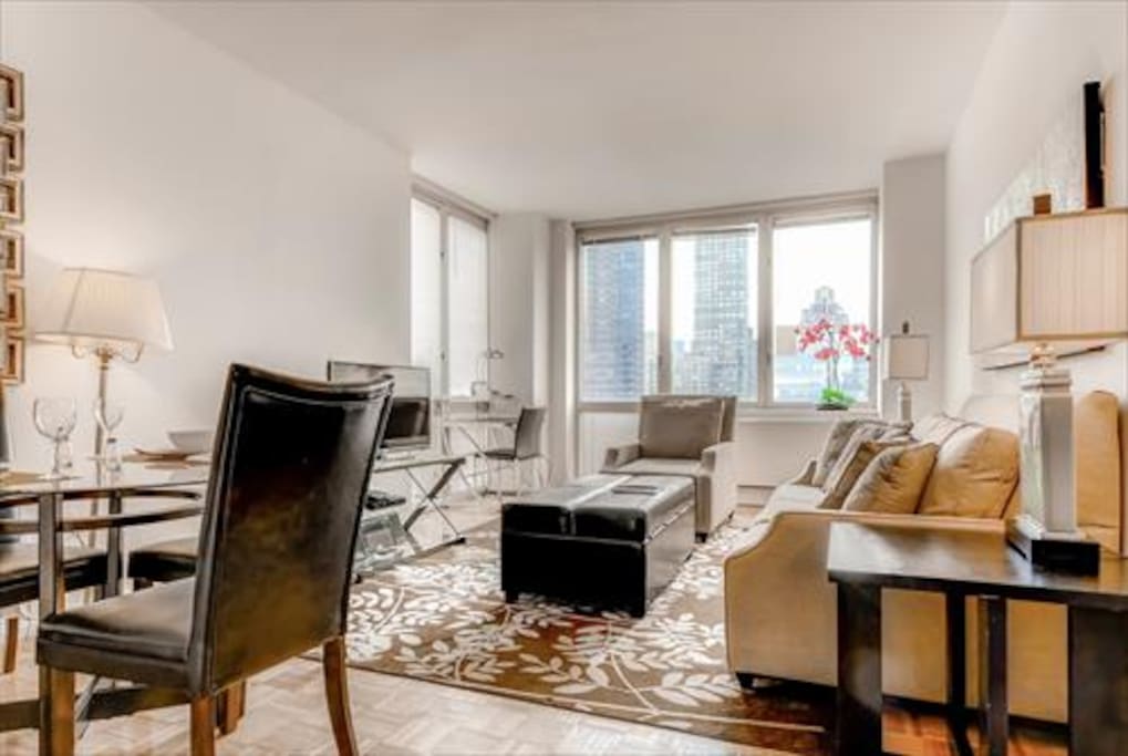 Spacious Living Room with pullout sofa bed as well as large windows to experience the city views