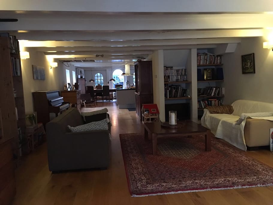 Living room, piano, kitchen area