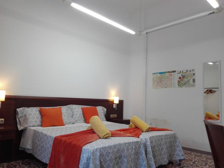 Habitación con dos o tres camas, terraza, aire acondicionado y calefacción.
