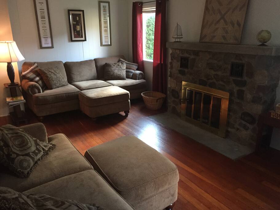 Living room with two spacious couches, a chair, a fireplace and a large screen tv.
