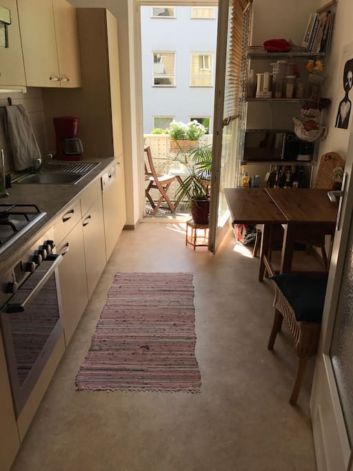 Fully equipped kitchen with access to balcony facing backyard