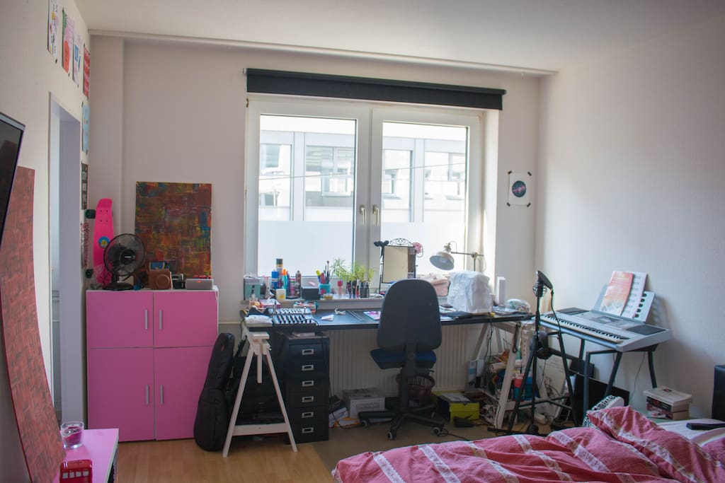Schlafzimmer mit großem Schreibtisch, Keyboard und Nähmaschine