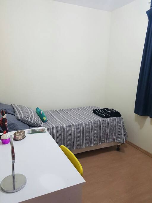 Cama de solteiro e estação de trabalho.