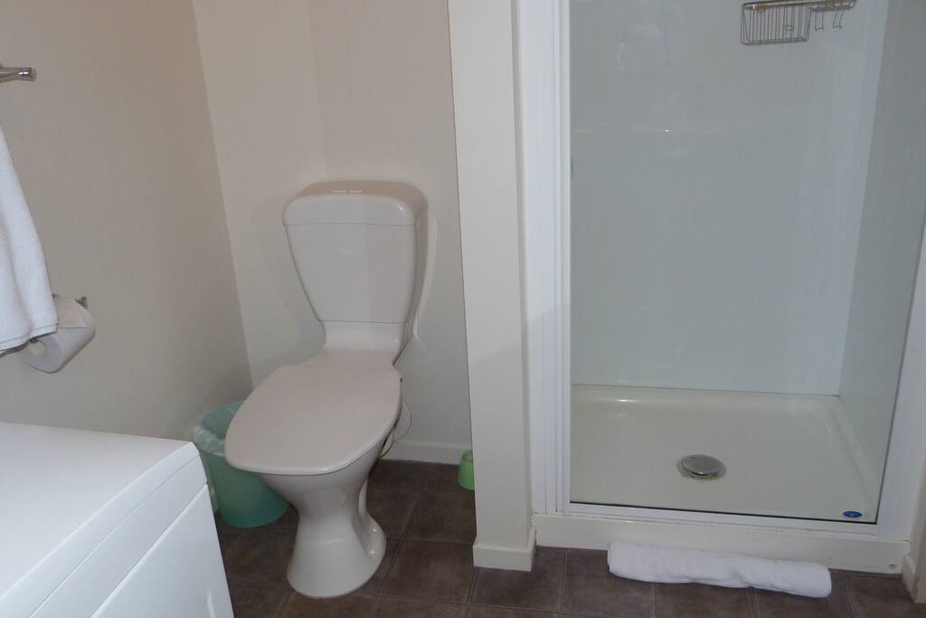 Bathroom, with shower, toilet, hand basin and washing machine (including basket and clothes rack).