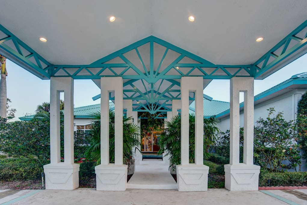 The front of the Tropical Retreat Estate Home has covered parking and a grand entrance.