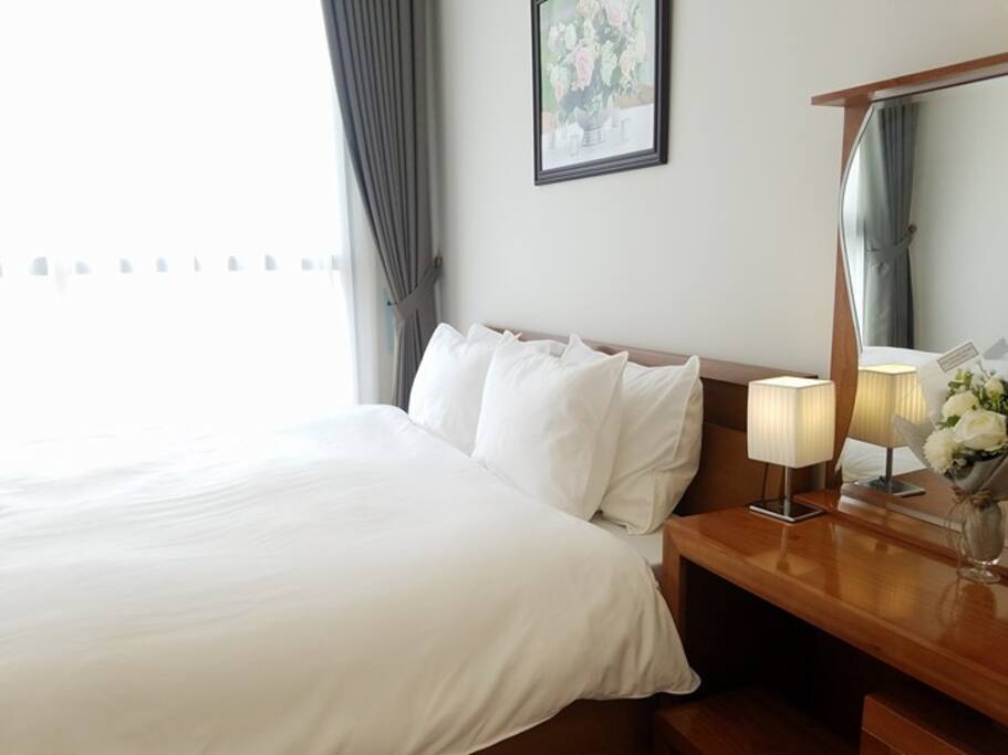 Comfy bed with thick mattress, bright natural light from big window