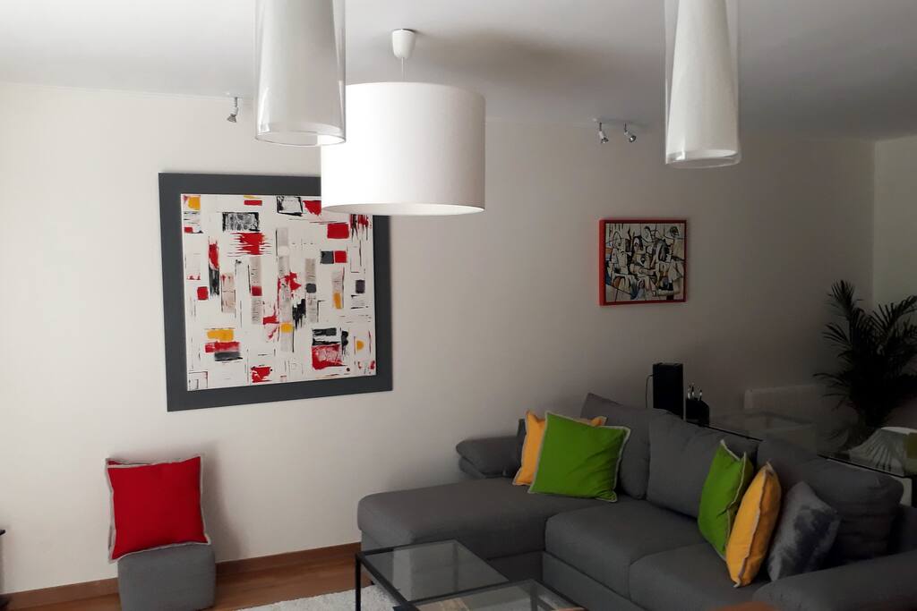 Salon avec grande baie vitrée donnant sur la terasse et le jardin, canapé 4 places + 4 poufs, transformable en un confortable lit de 140cm, TV écran plat, Coin bureau