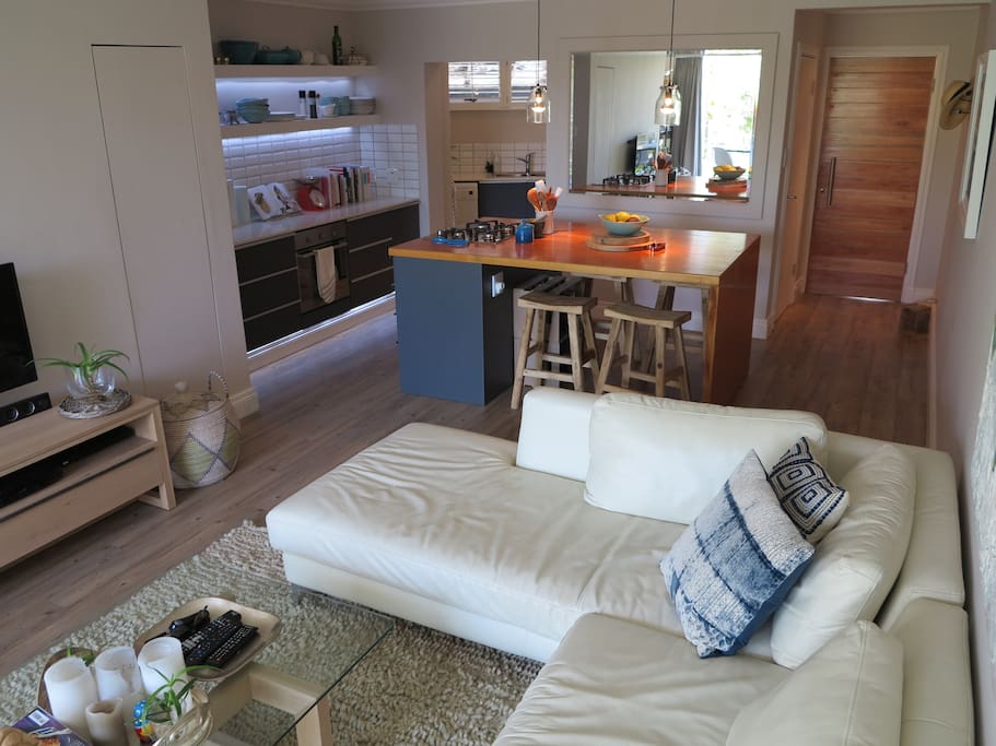 Open plan living space large with leather couch.