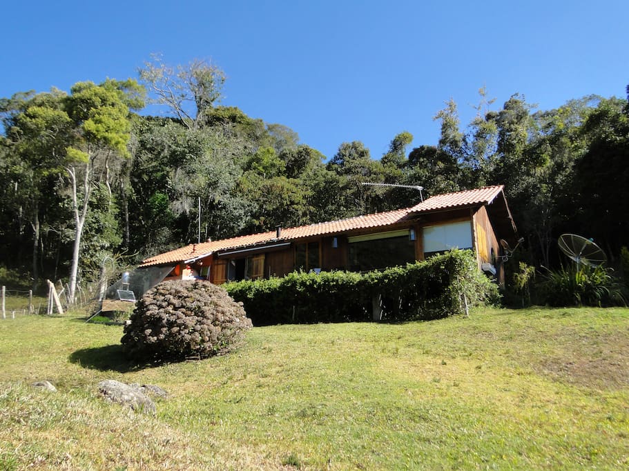 Casa em madeira com amplo deck, sauna a lenha e ducha.