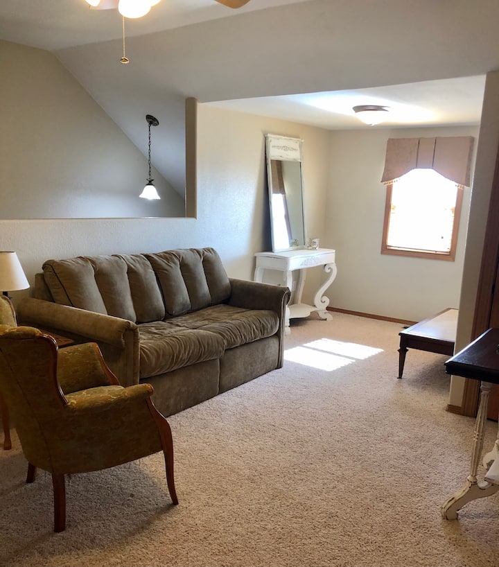 Loft en el segundo piso con televisión por streaming y sofá cama.