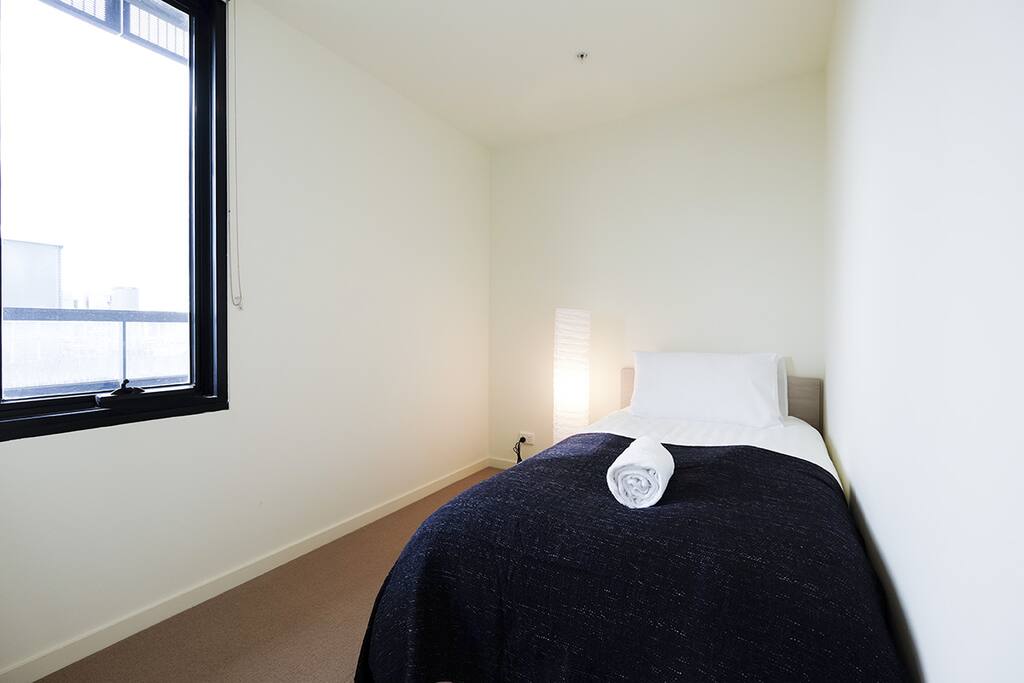Well-lit single bedroom.