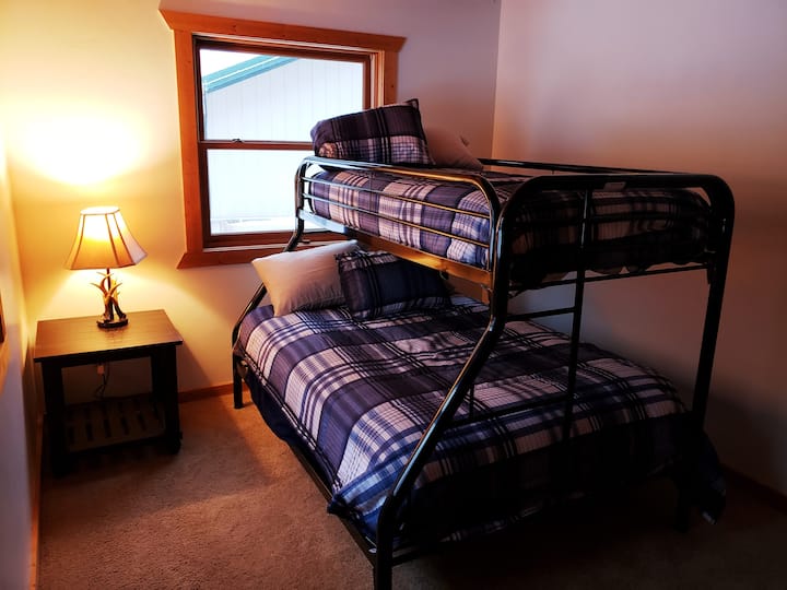 This first floor bedroom with a door is great for kids but yet comfortable for adults with a pillow top mattress on the bottom bunk. With plenty of room the bunk is pulled out from the wall and accessible from both sides. A full bath room is nearby.