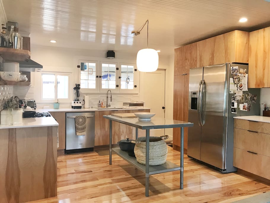 Open and bright newly remodeled kitchen with a dishwasher, gas range and oven, toaster oven and large refrigerator. The door in the back corner leads to the mudroom on the back side of the house. Access the deck through this door.