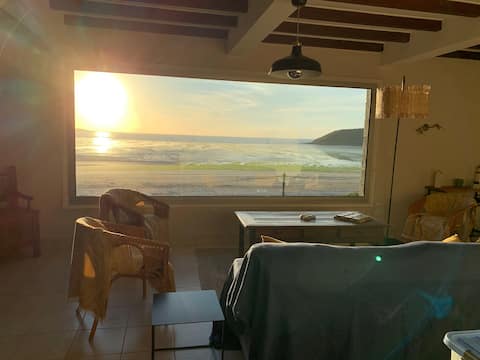 Large house with sea view above the beach.