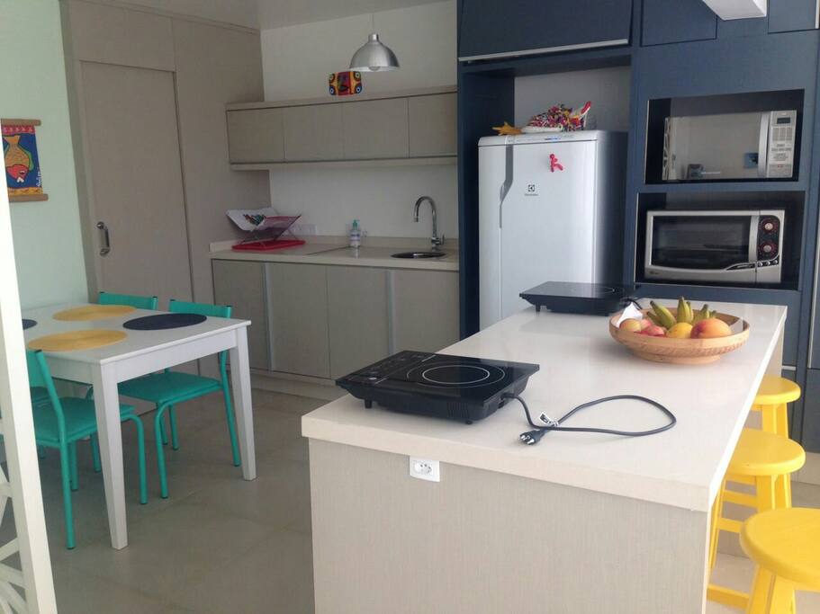 Cozinha bem planejada com bancada gourmet e vista para o mar...