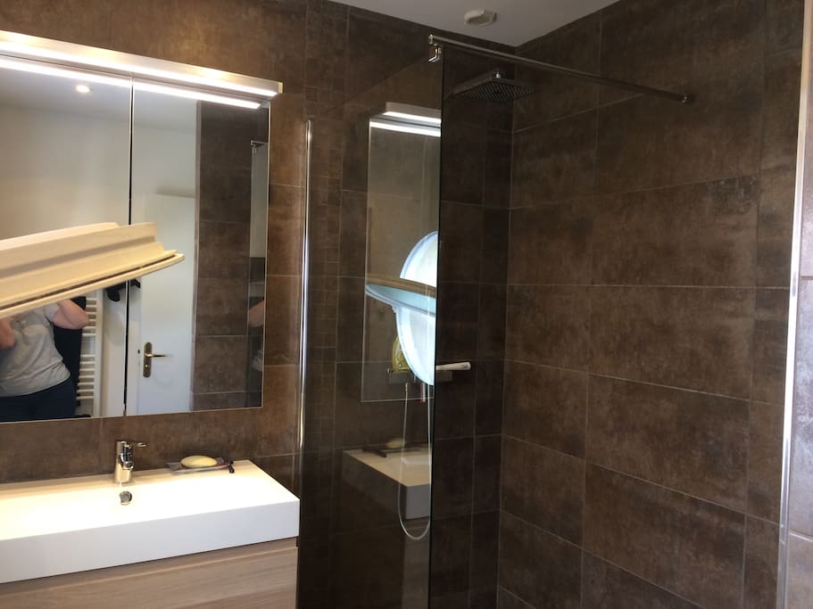 Salle De douche à l'italienne neuve avec fenêtre et armoires