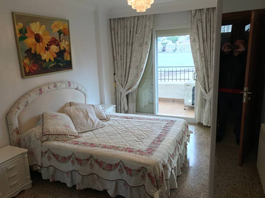 Habitación principal con cama matrimonio y balcón con vista al mar .