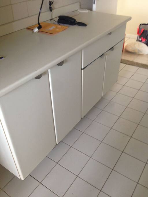 Móveis planejados na cozinha e piso de cerâmica.