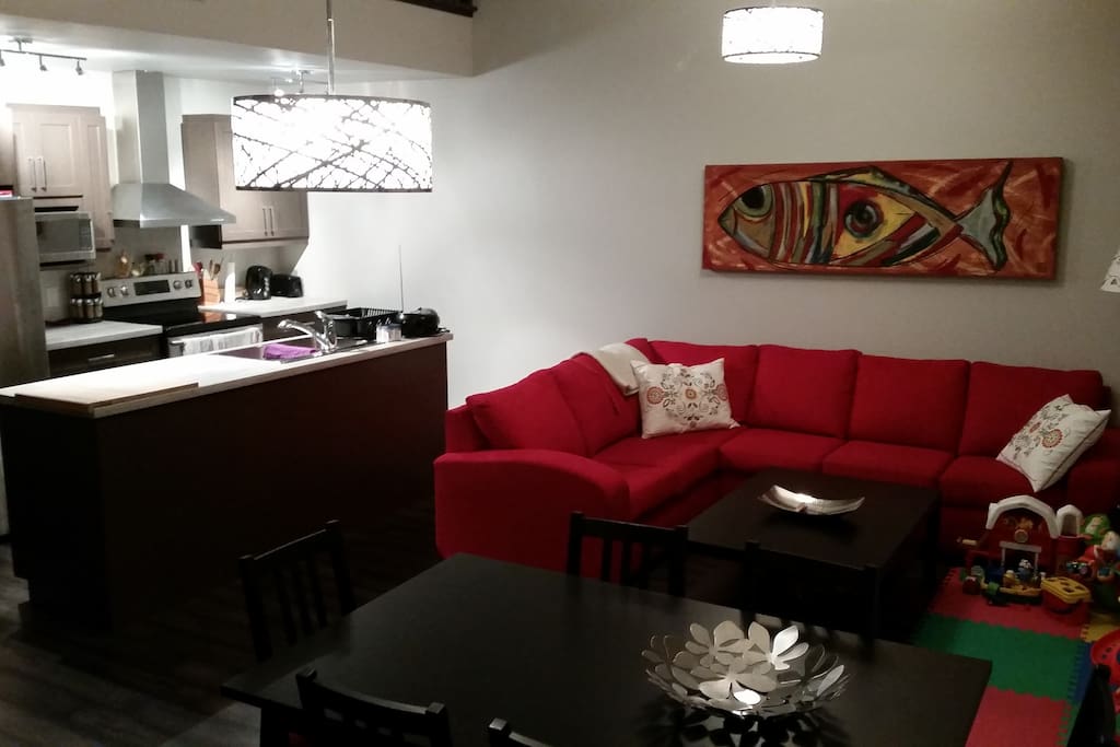Salon, cuisine et salle à manger dans un espace ouvert avec plafond cathédrale