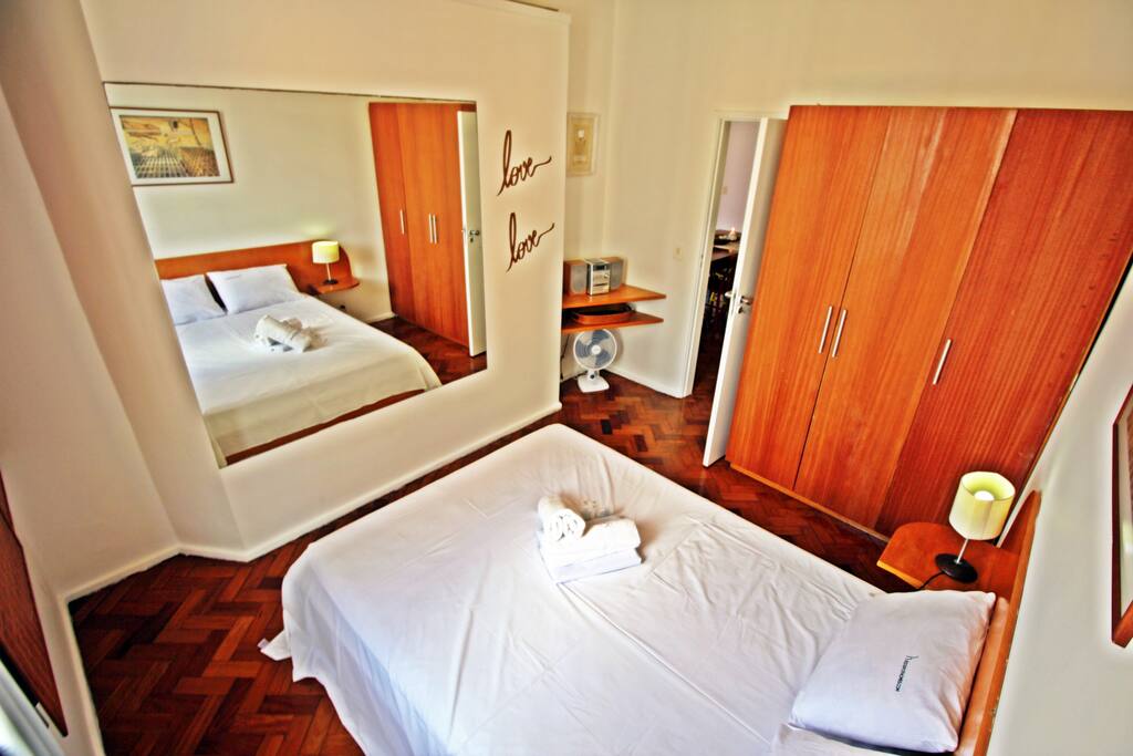 Quarto 1 com cama de casal, ar condicionado e armários.