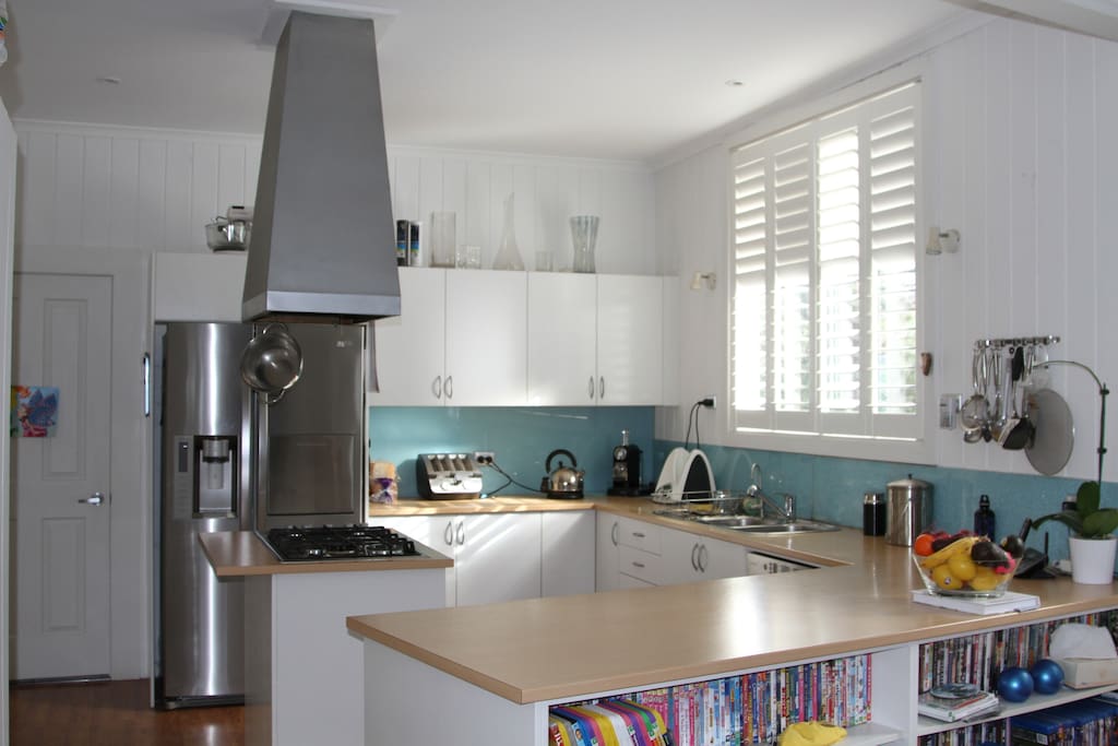 Kitchen with modern appliances opening to family room, lounge and large flat screen TV