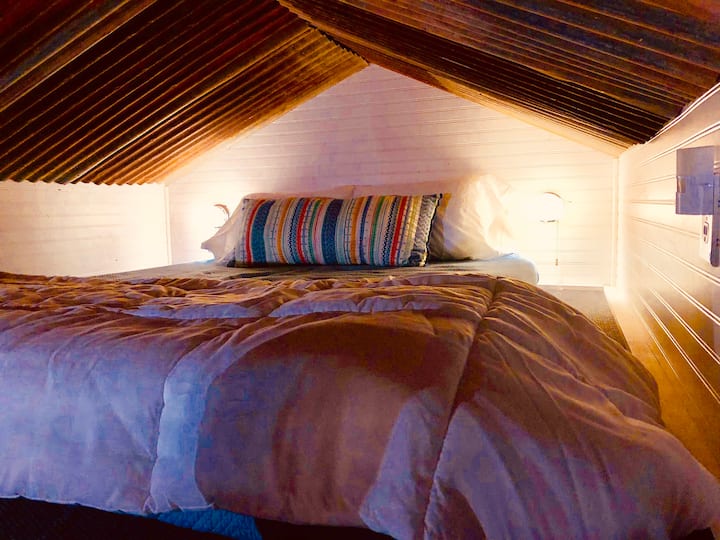 Спално помещение, матрак с двоен размер. Старият калай в хамбара съставлява тавана в цялата малка къща.