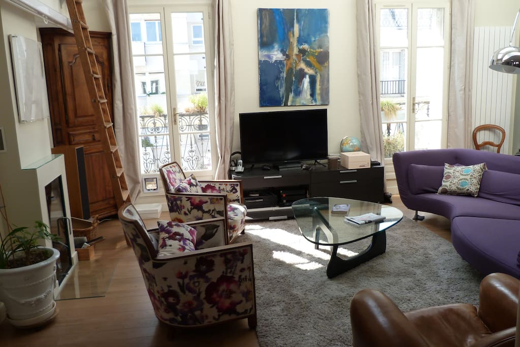 le salon exposé plein sud avec double fenêtres donnant sur balcon