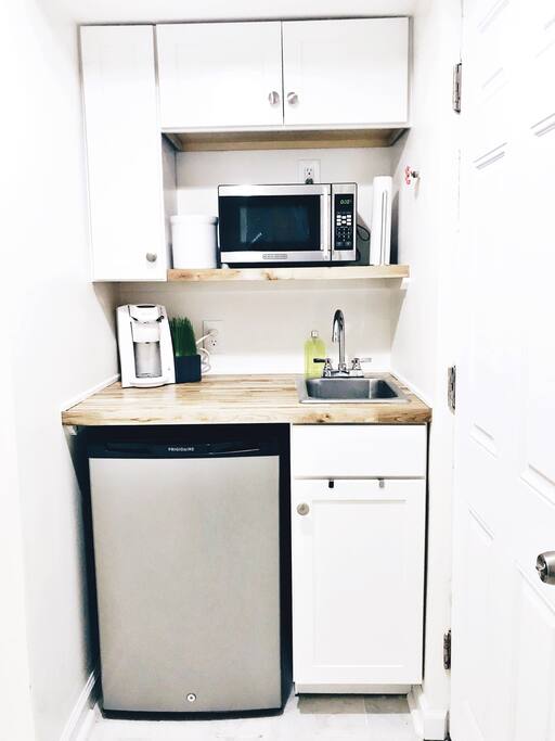 Private kitchenette in the basement with refrigerator, freezer, microwave, coffee maker, and full sets of dishes, glasses, and silverware for exclusive guest use.