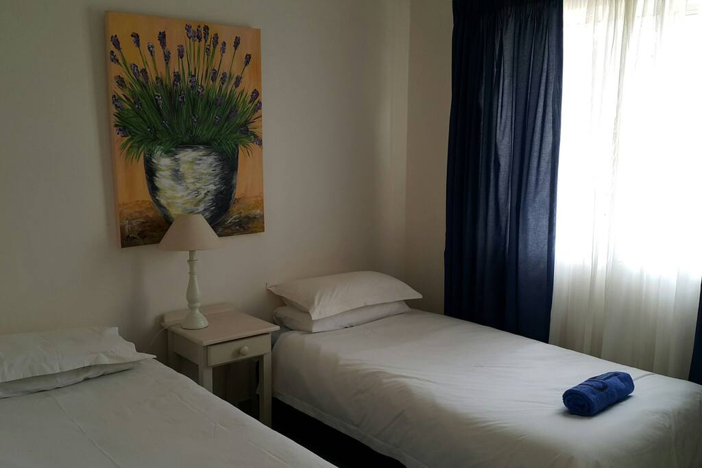 Second bedroom with two single beds and built in cupboards