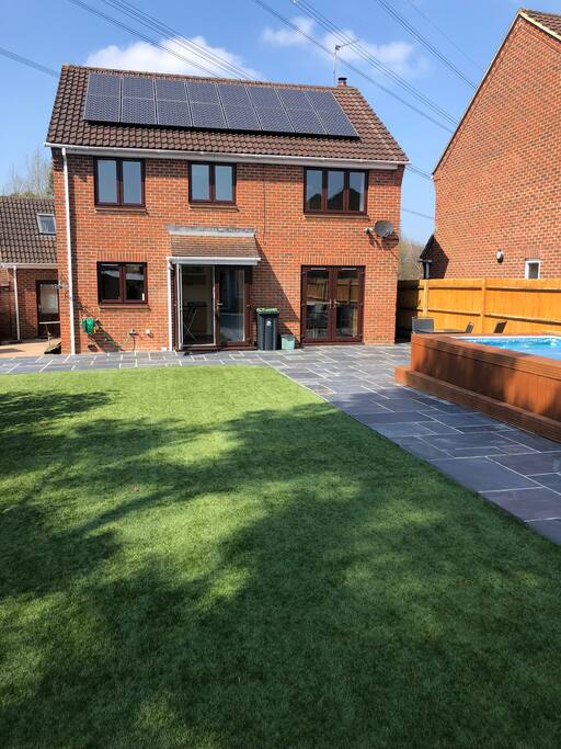 Large back garden with artificial grass and heated pool
